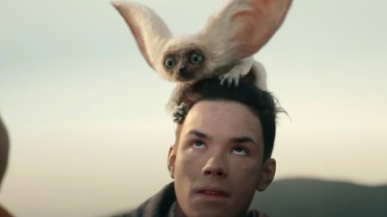 Momo, a white creature with large ears, lands on Sokka's head.