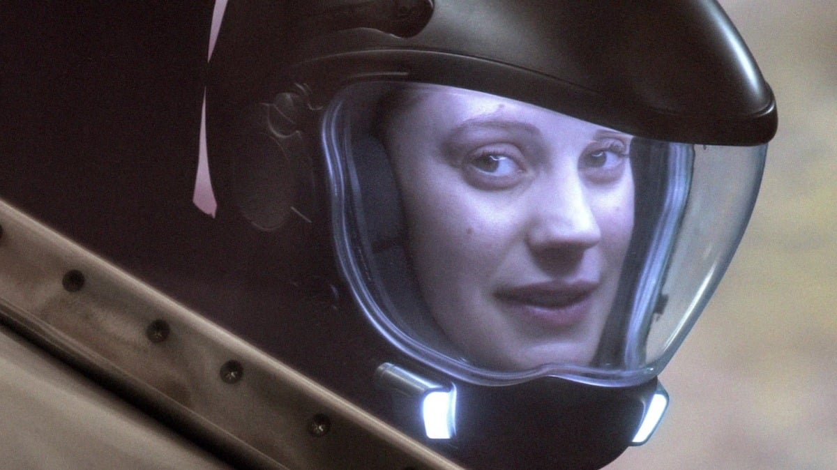 Starbuck (Katee Sackhoff) looks out of the cockpit of her viper, wearing her helmet.
