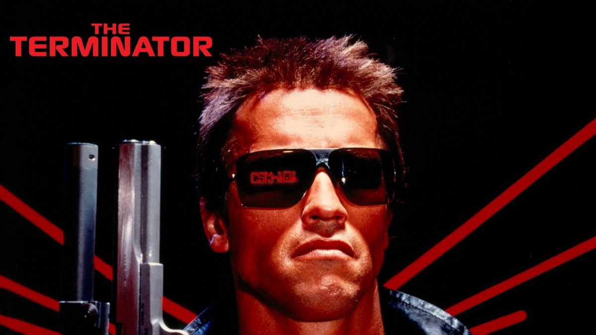 The terminator holds a gun with red neon reflected in his sunglasses in "the terminator" 