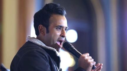 Vivek Ramaswamy yells into a microphone.