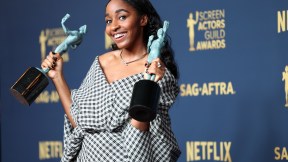 Ayo Edebiri holding up her two SAG awards and smiling at the camera