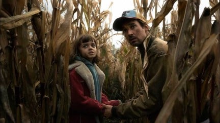 Florian David Fitz as Sven and Yuna Bennett as Charlie holding hands in a corn field in The Signal