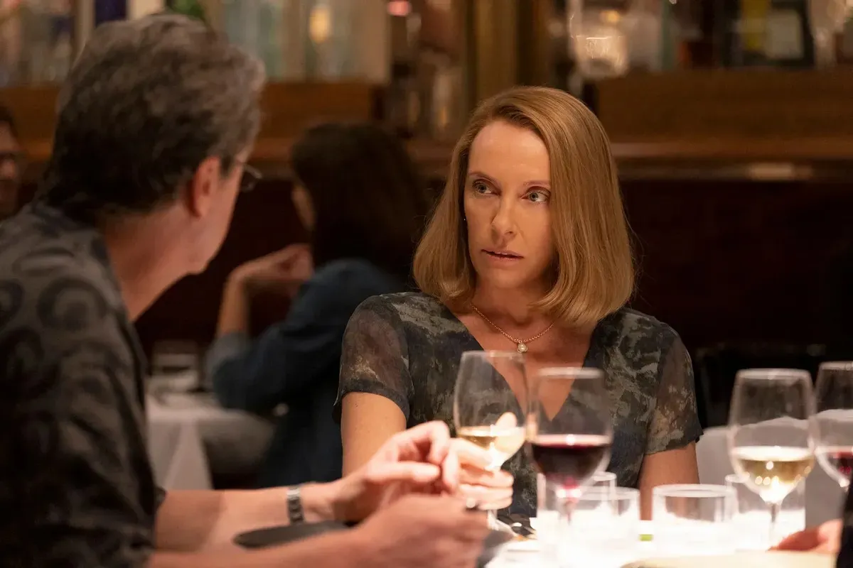 Toni Collette sitting at a dinner table in The Staircase