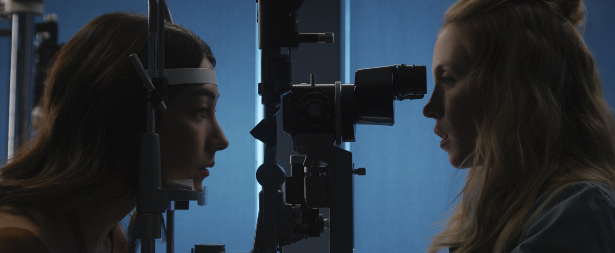 two woman look at each other through optometrist equipment in The Voyeurs