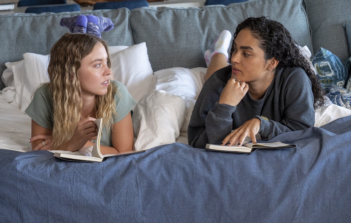 Sydney Sweeney and Brittany O'Grady lie in bed on their stomachs looking at each other in White Lotus
