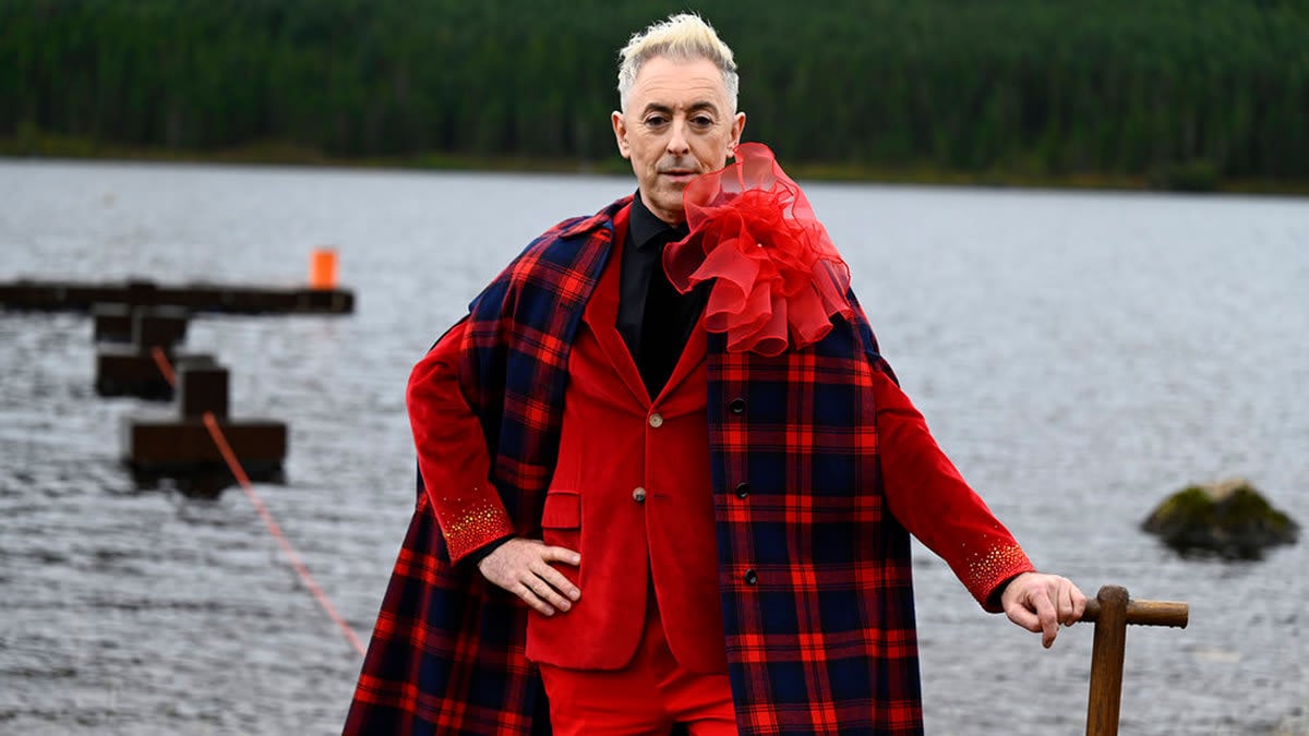 Alan Cumming sports a red tartan cape and suit in season 2 of 'The Traitors'.