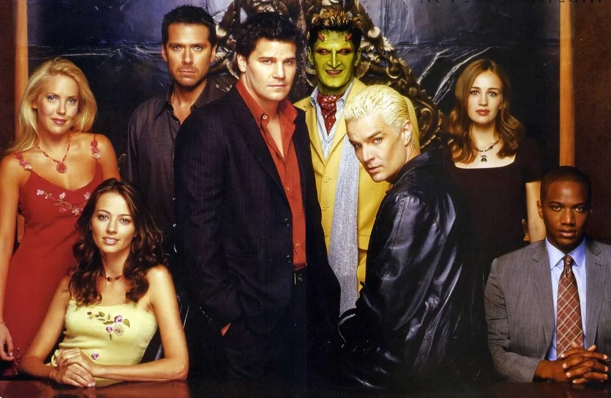 The cast of Angel all posing together with Spike sitting on a desk