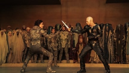 Feyd-Rautha Harkonnen (Austin Butler) and Paul (Timothée Chalamet standing with swords across from each other in Dune