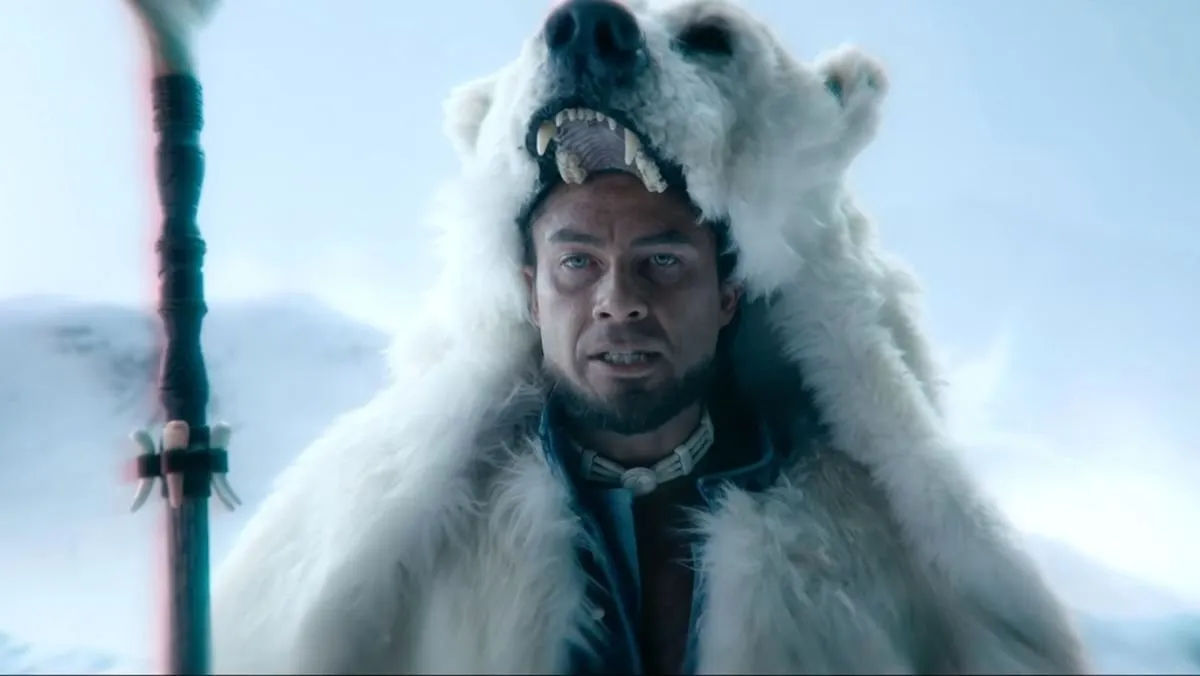 Avatar Kuruk, wearing a polar bear skin over his head and holding a staff.