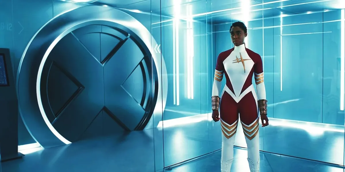 Lashana Lynch as Binary, standing next to a round door with an X on it.