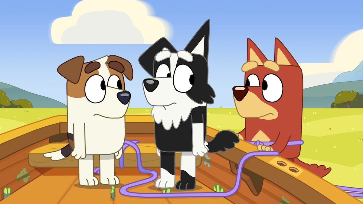 Jack, Rusty, and Mackenzie stand in a rowboat in the middle of a field.