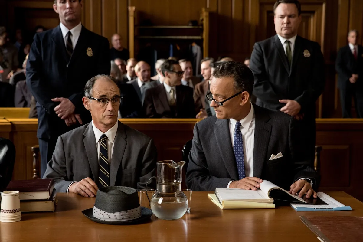 Mark Rylance and Tom Hanks sitting at a table in a court room together