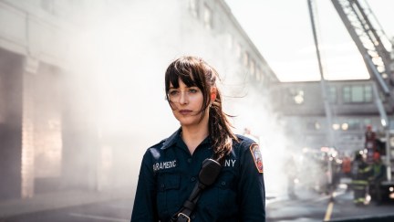 Cassandra Web standing in the midst of chaos in her paramedics outfit
