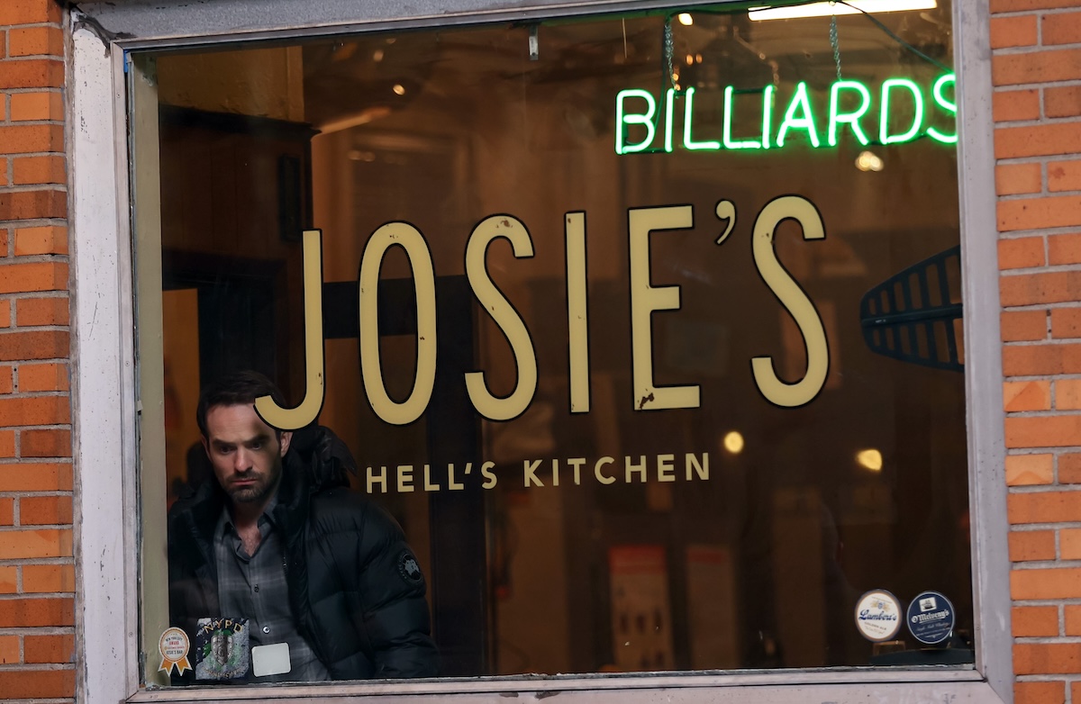 Charlie Cox standing in the window of Josie's Bar