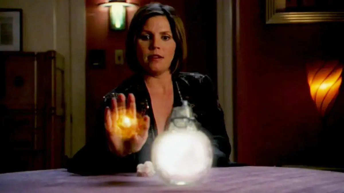 Cordy doing a magic spell, sitting at a table with her hand glowing