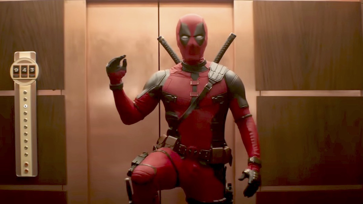 Deadpool pumps his fist and lifts one leg in an elevator.