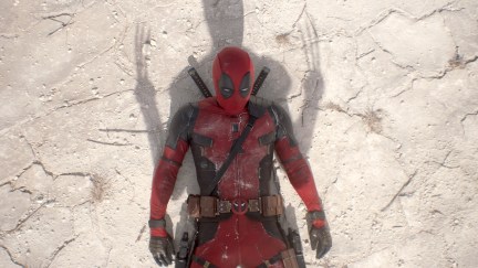 Deadpool laying on the ground with Wolverine standing above him