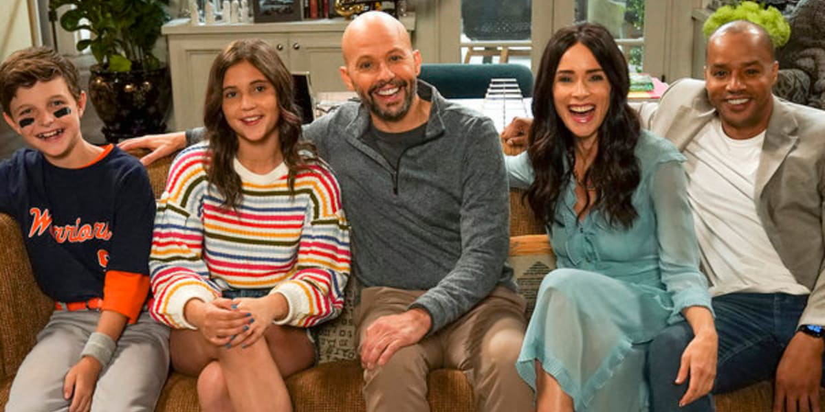 The cast of Extended Family all sitting on a couch together