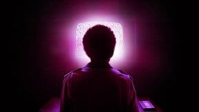Detail of the poster of I Saw the TV Glow, showing the back of Owen's head against a purple glowing TV screen.