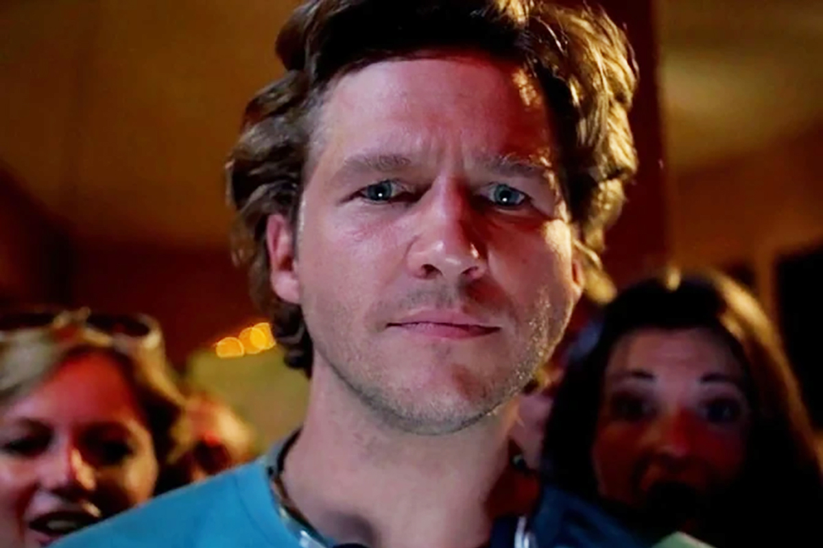 Jeff Bridges staring at the camera with people behind him in Tron