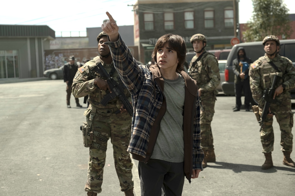 Azhy Robertson pointing at the sky in the middle of the road