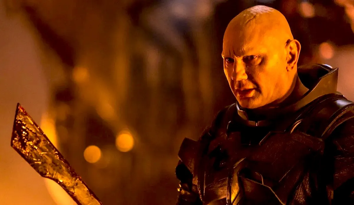 Dave Bautista as Rabban in Dune: Part Two, holding a large blade.
