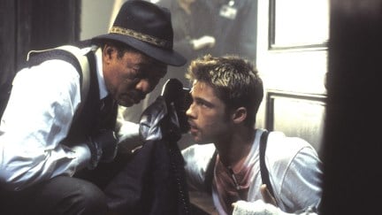 Morgan Freeman huddled with a phone up to Brad Pitt's ear in the movie Se7en