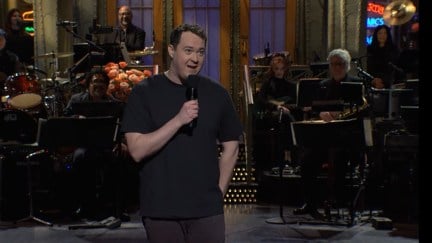 Shane Gillis holds a microphone while delivering his opening monologue on 'Saturday Night Live'.