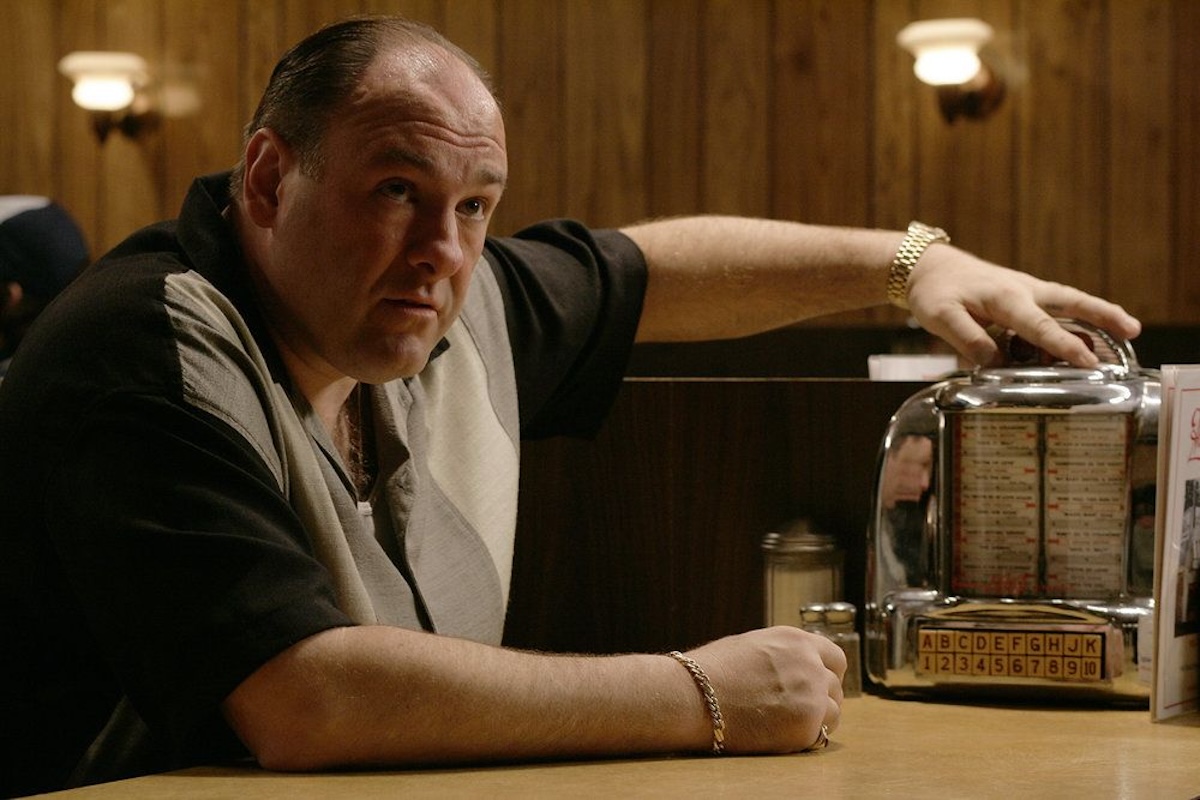 Tony Soprano sitting at a diner table with his arm on a jukebox