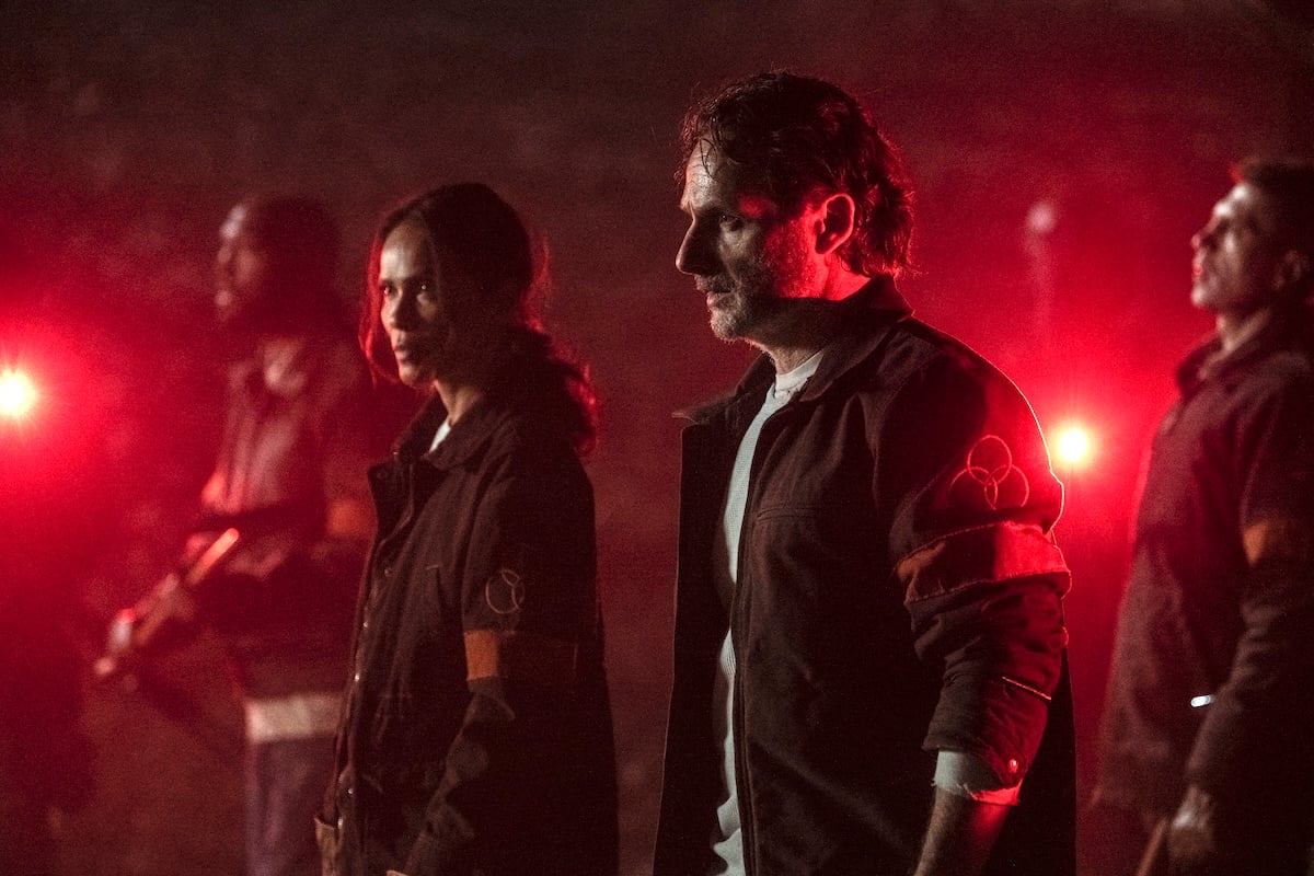 Rick and Thorne standing in a red light and looking strong in the walking dead the ones who live