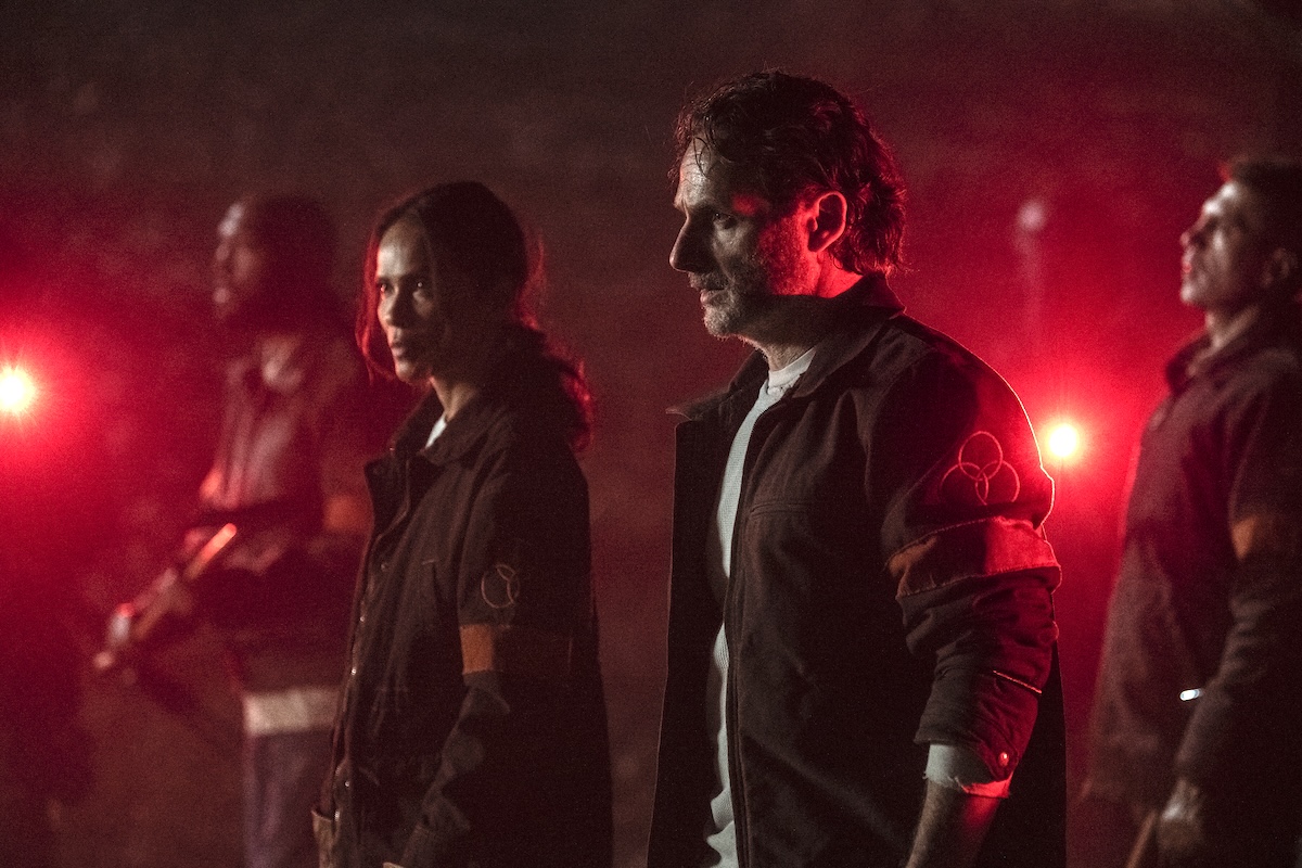 Rick and Thorne standing in a red light and looking strong in the walking dead the ones who live