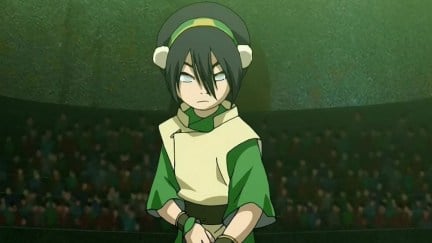 Toph stands in a fighting stance in a dimly lit arena in Avatar: The Last Airbender