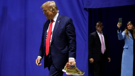 Donald Trump appears at Sneaker Con to sell his gold sneakers.