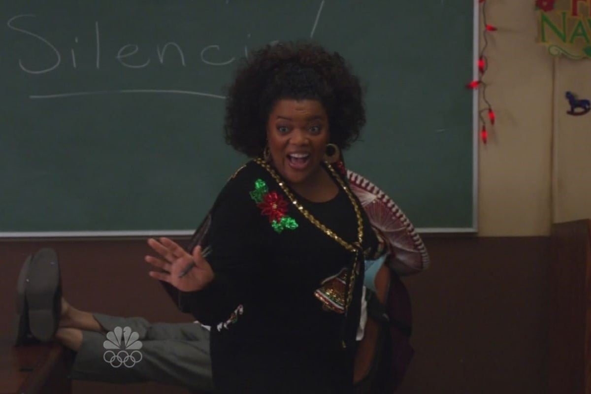 Still from Community episode Comparative Religion; Yvette Nicole Brown, a black woman with natural hair, speaks animatedly while wearing a black Christmas sweater.