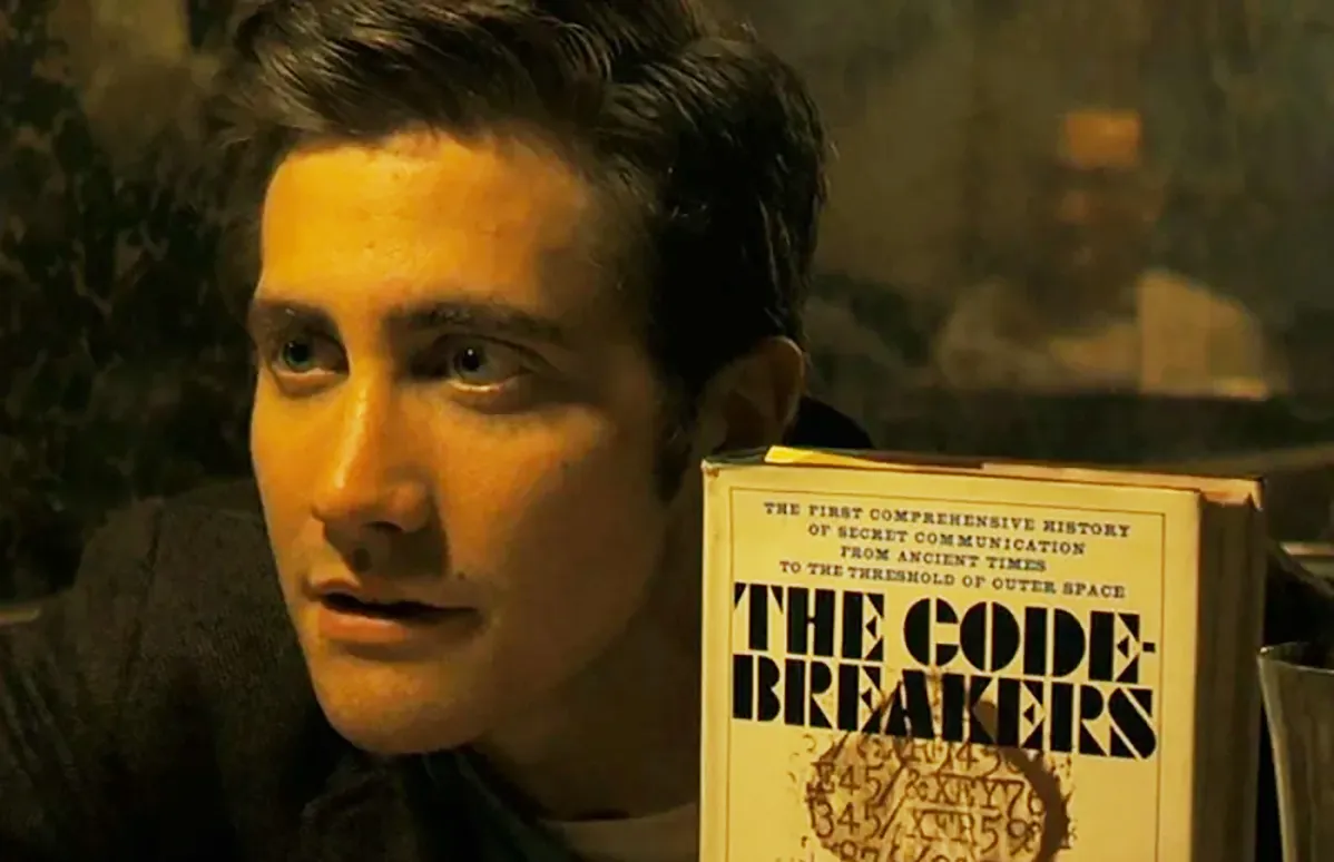 Jake Gyllenhaal holding up a book that says Codebreakers in Zodiac