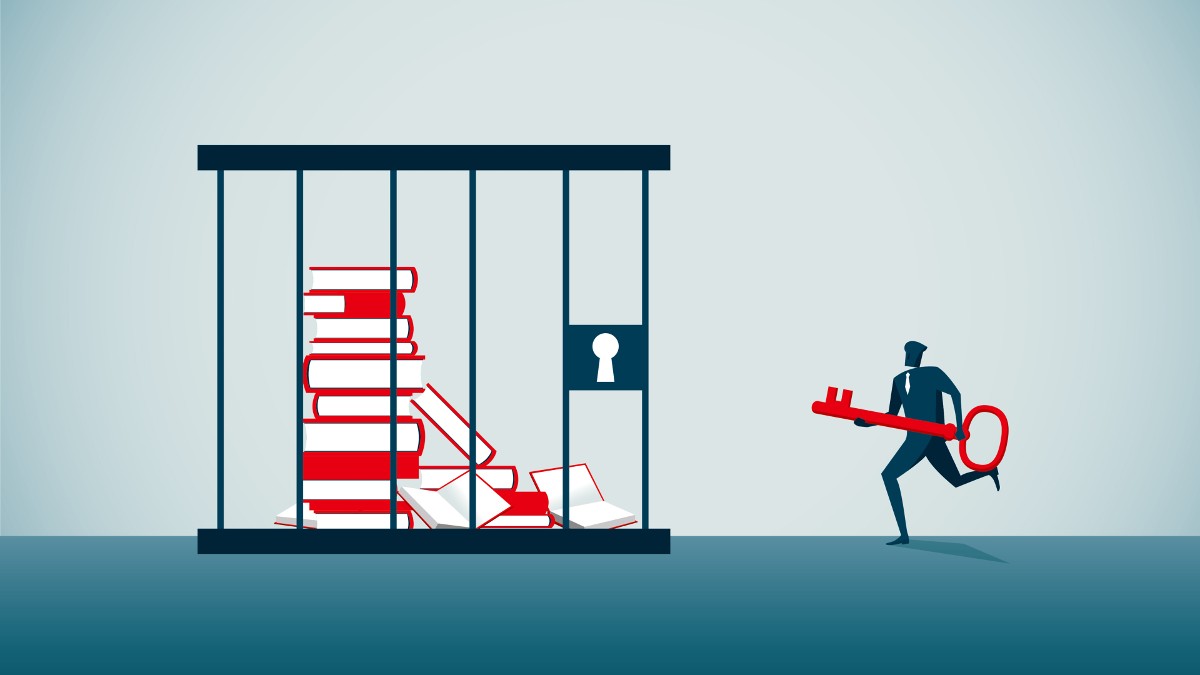 A man with a key approaches books locked up in a jail cell