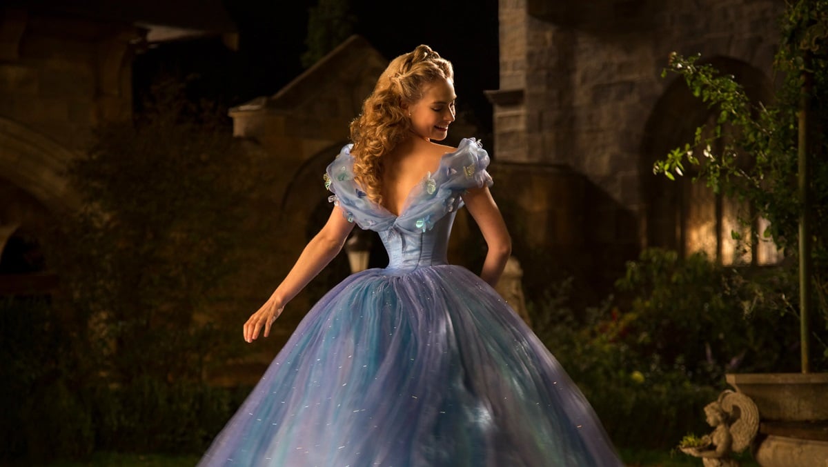 Lily James twirls in a blue ball gown