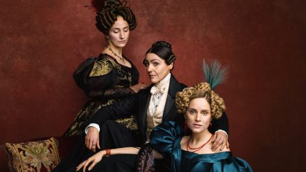 Three women in Victorian British clothing against a red background.