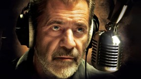 Close up of Mel Gibson's face wearing headset and leaning into a radio microphone