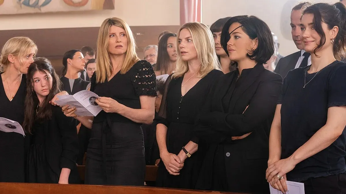 The five actresses of 'Bad Sisters' wear black and stand at a funeral.