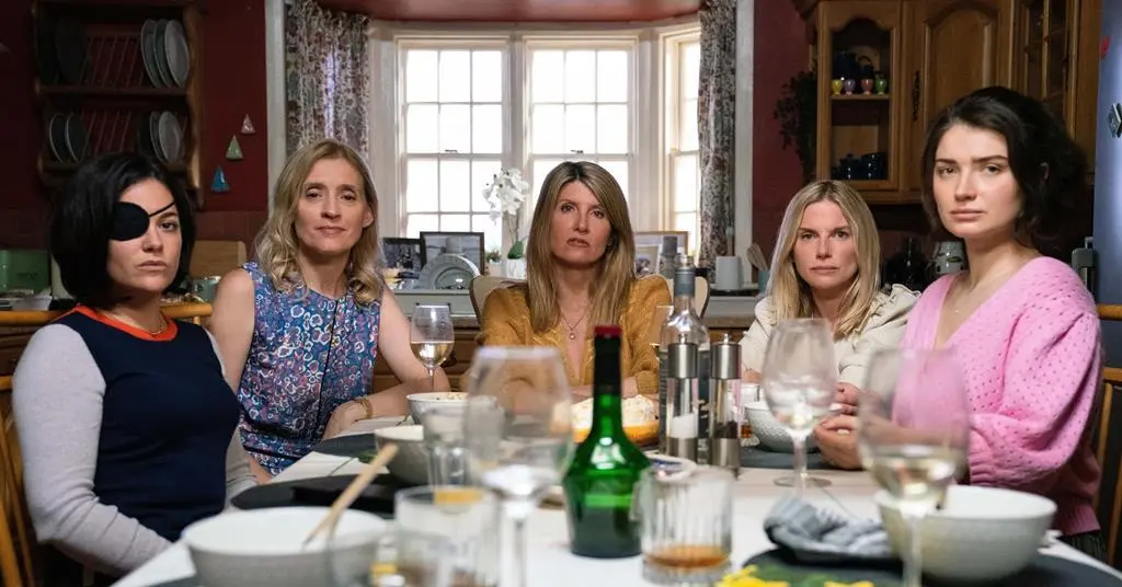 The Garvey sisters sit around a table in 'Bad Sisters'.