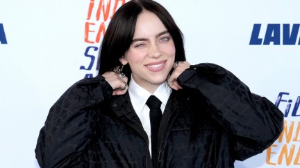 Billie Eilish winking at the camera on a red carpet
