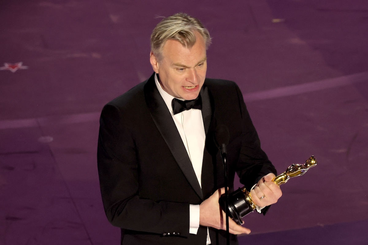 Christopher Nolan standing on stage with his Oscar