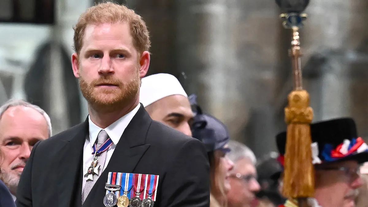 Prince Harry wearing formal dress and medals, looks on at an event.