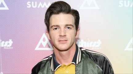 Drake Bell in a collared shirt and jacket.