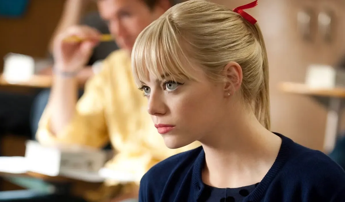Emma Stone in a pony tail sitting in a classroom