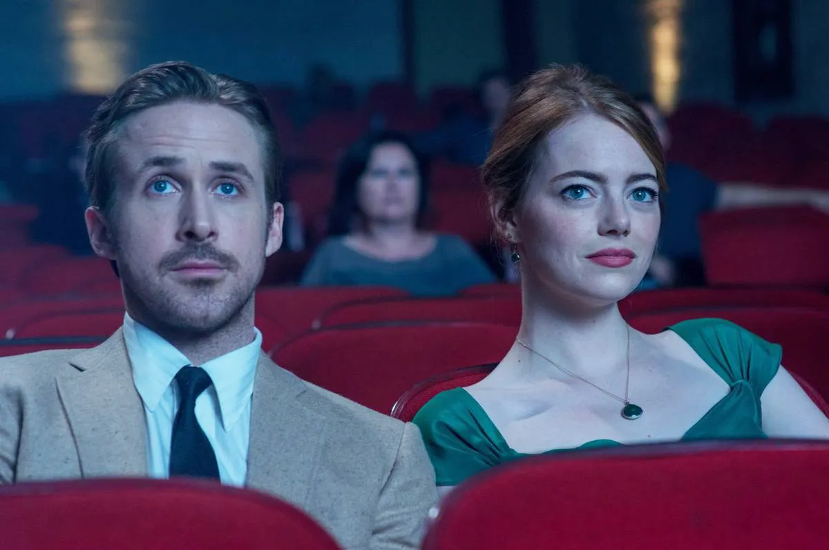 Ryan Gosling and Emma Stone sitting next to each other in a movie theater