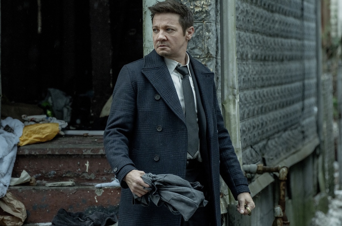 Jeremy Renner holding a coat in mayor of kingstown
