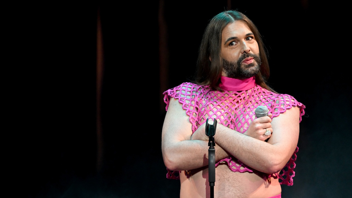 Jonathan Van Ness with their arms crossed standing on stage