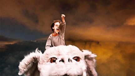 Bastian pumps his fist while riding Falkor in The Neverending Story.
